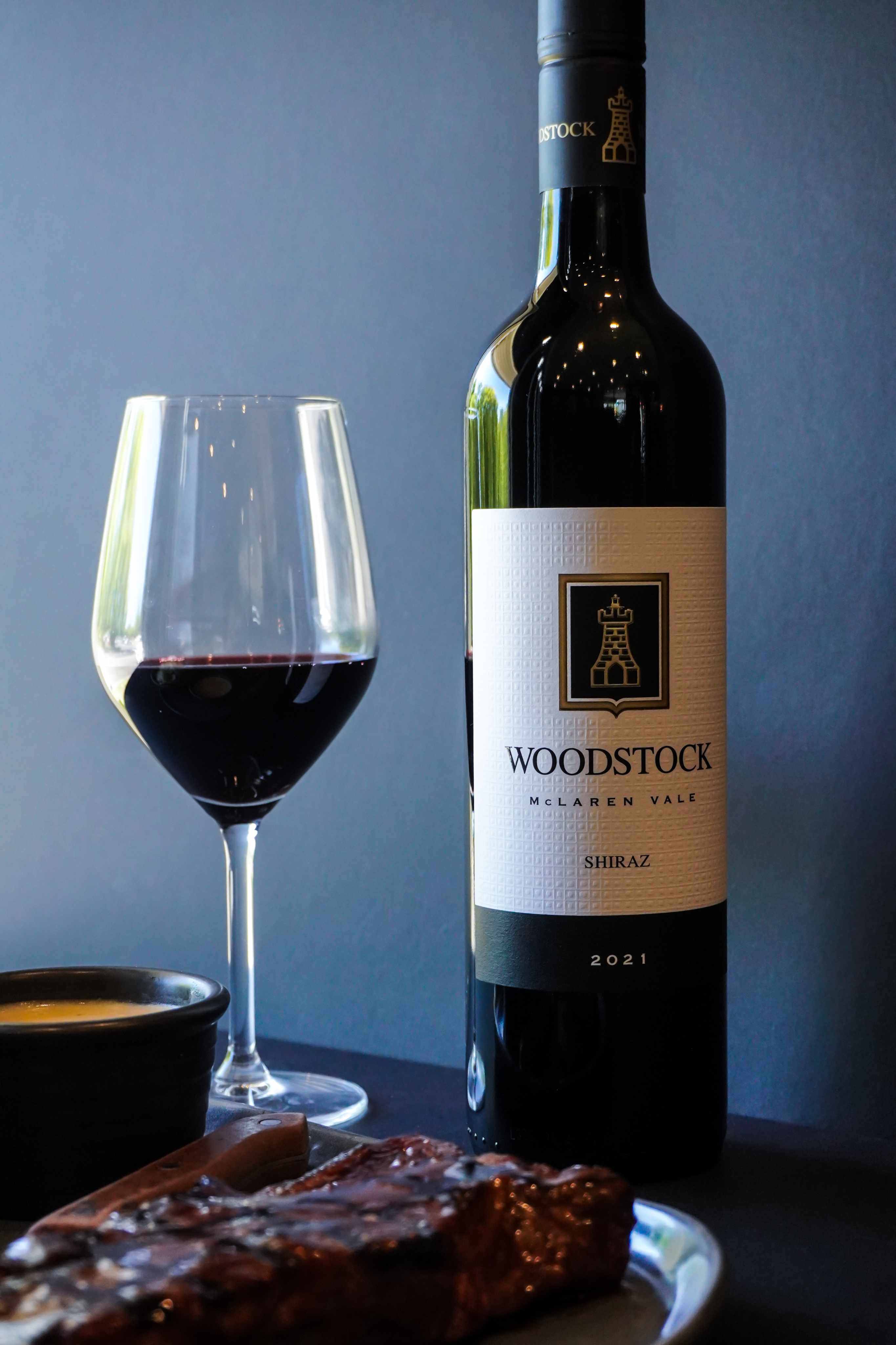 PLACEHOLDER — Wine - logo.png: The Hill logo etched on a red-wine glass next to bottle